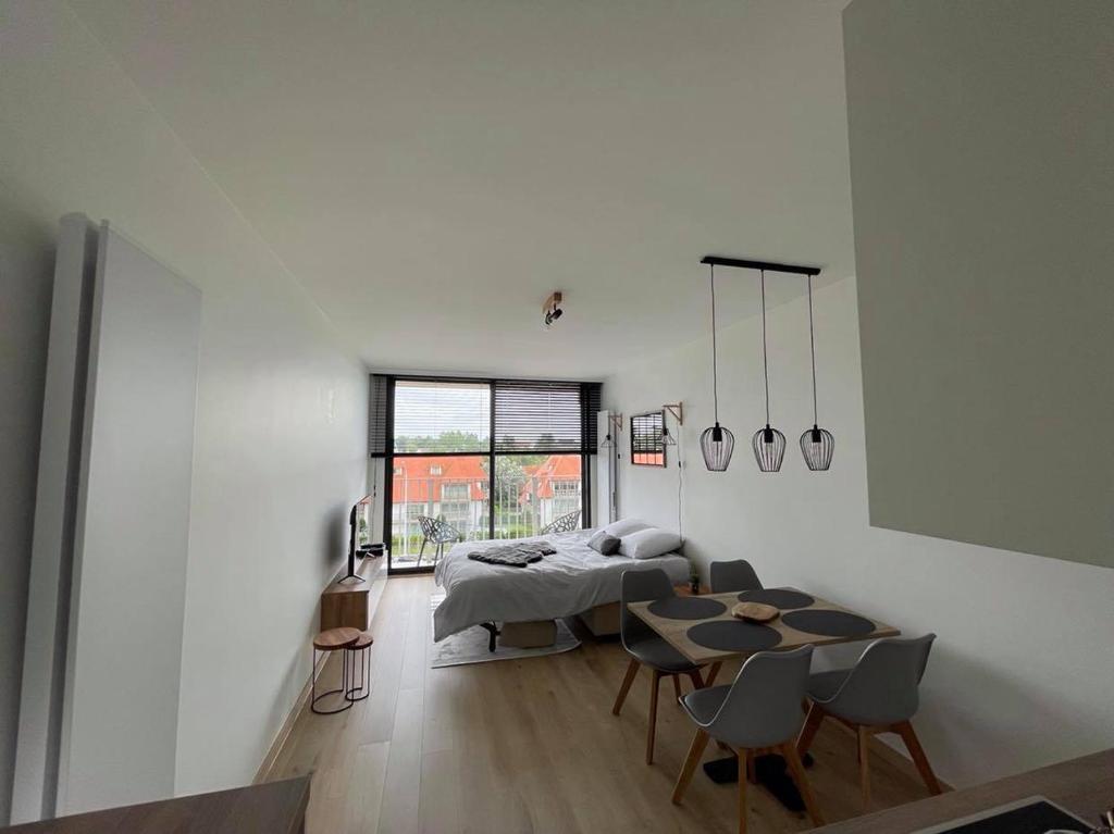 Habitación con cama, mesa y sillas. en Work or holiday nieuw studio Santhooft, en Nieuwpoort