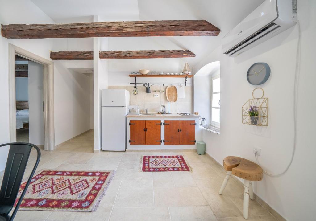 eine Küche mit Holzschränken und einem weißen Kühlschrank in der Unterkunft Apartments Oliva in Risan