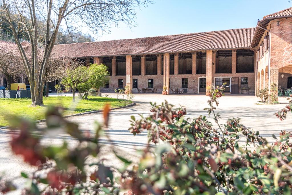 eine Außenansicht eines Gebäudes mit Bäumen im Vordergrund in der Unterkunft Marchesi Incisa Winery Lodge in Rocchetta Tanaro