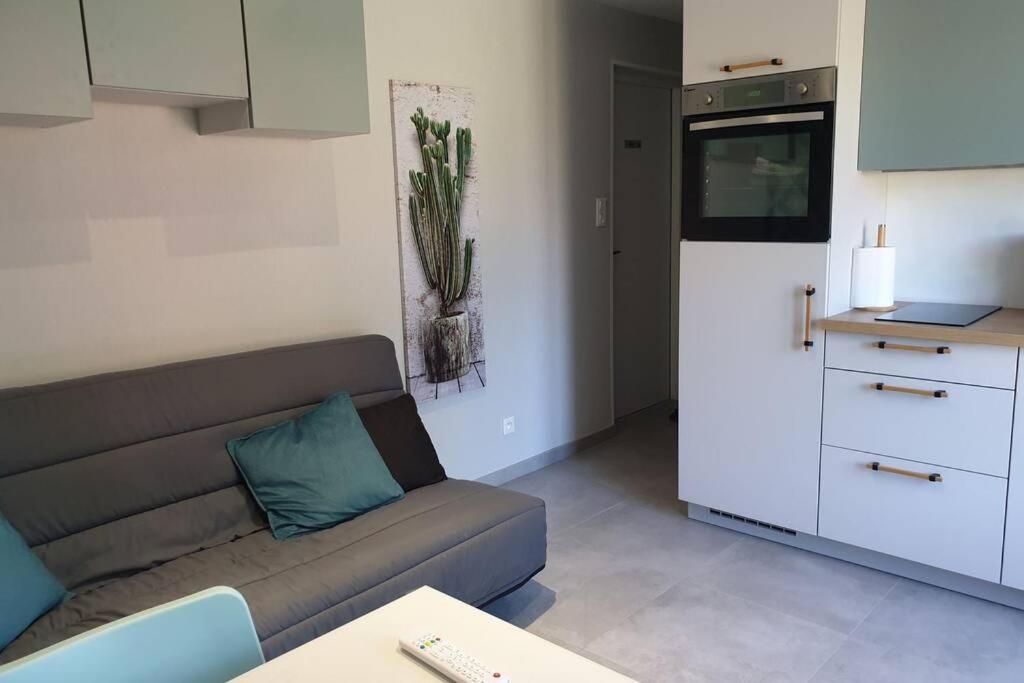 a living room with a couch and a kitchen at Agréable logement pour 4 pers à deux pas de Verdun in Haudainville