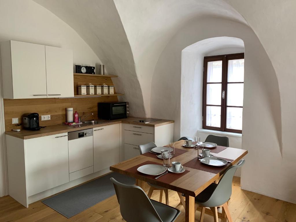 eine Küche und ein Esszimmer mit einem Tisch und Stühlen in der Unterkunft Ferienhaus beim Turm in Breitenbrunn