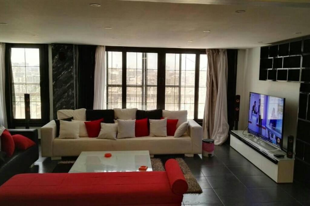 a living room with a couch and a tv at Luxurious & Large Modern Penthouse in Cairo