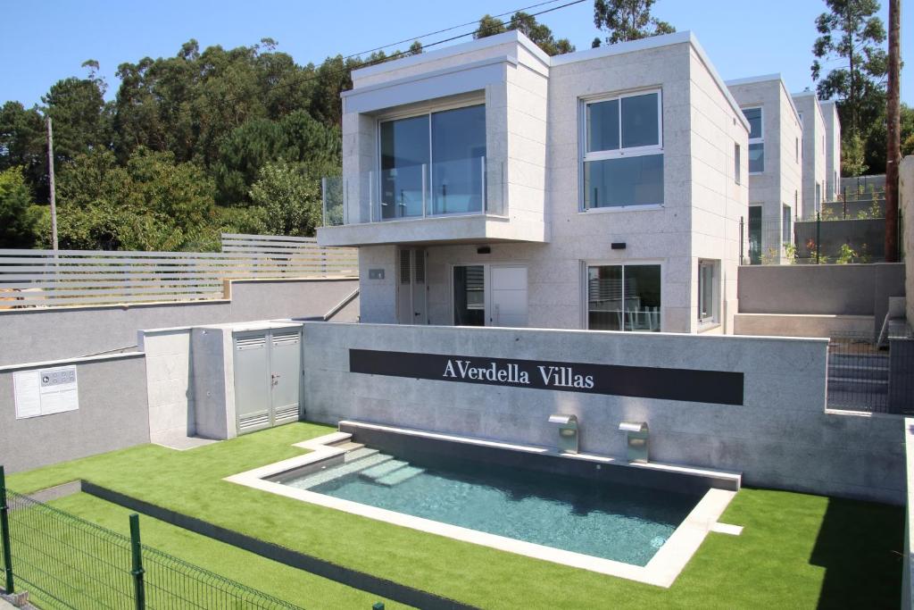 a modern house with a swimming pool in the yard at A Verdella Villas in Sanxenxo