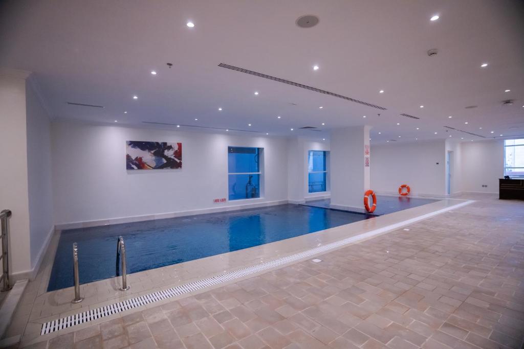 een groot zwembad in een grote kamer met een zwembad bij The Gate Hotel and Apartments in Dammam