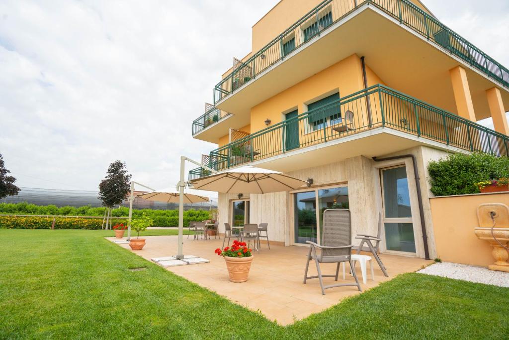 a house with a patio and an umbrella at Agriturismo Corte Ambrosi in Pescantina