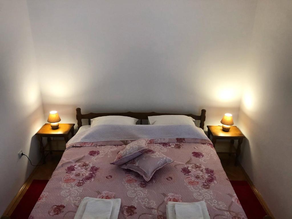 - une chambre avec un lit et deux lampes de chaque côté dans l'établissement Casa di Zanjic, à Luštica