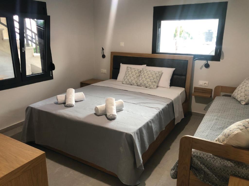 a bedroom with two beds with towels on them at Aurora Apartments in Nea Vrasna