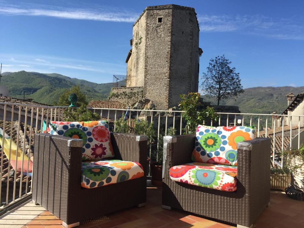 a pair of chairs on a patio with a tower at Attico con Terrazza panoramica vista lago - LAKEHOLIDAY IT in Castel di Tora