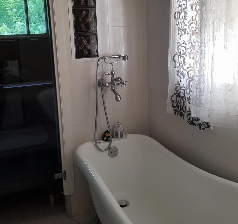 Rauhaa, hyvää unta maaseudulla في Loppi: حوض استحمام أبيض في حمام مع نافذة