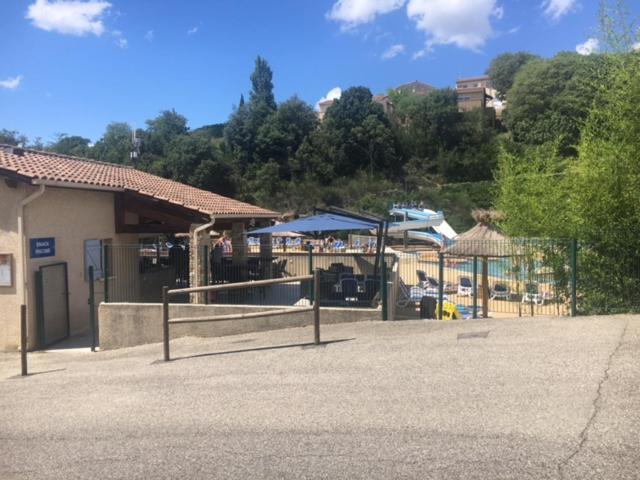 eine Terrasse mit Sonnenschirmen vor einem Gebäude in der Unterkunft Odalys , hauts de Salavas in Salavas