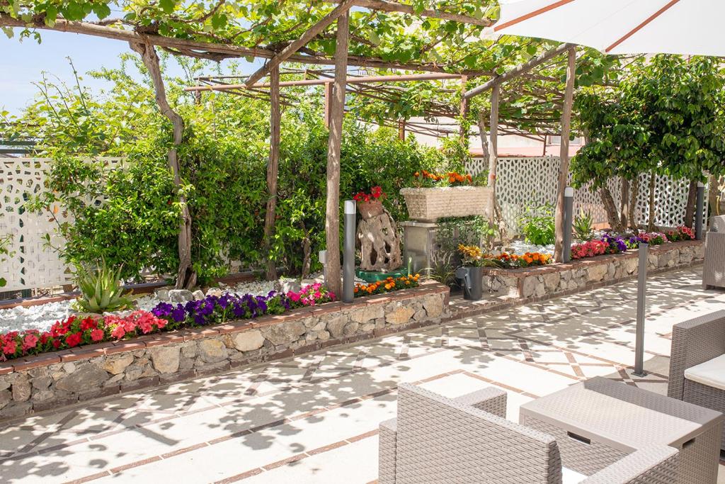 un giardino fiorito con pergolato di Il Cortiletto ad Agerola
