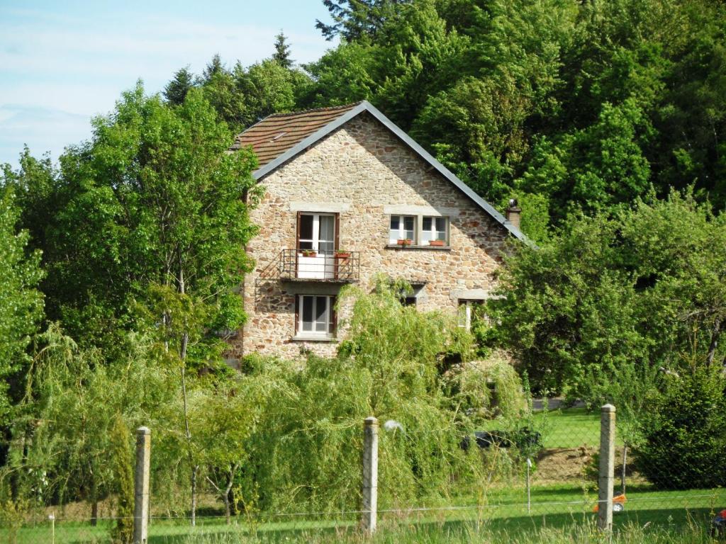 a stone house on a hill with trees at Domaine du Sable in Saint-Julien-aux-Bois