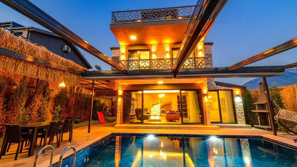 una casa con piscina delante de una casa en Söğüt 1 - 4 Bedroom with jacuzzi in Fethiye, en Fethiye