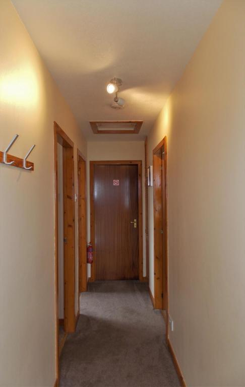 a hallway in a house with a hallway leading to a door at Riverside in Tarbert