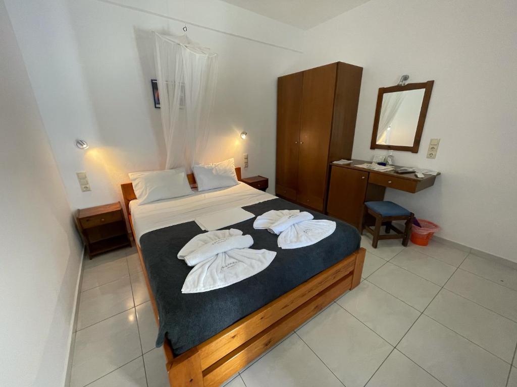 a bedroom with a bed with two towels on it at Pension Panorama in Kalamaki Heraklion