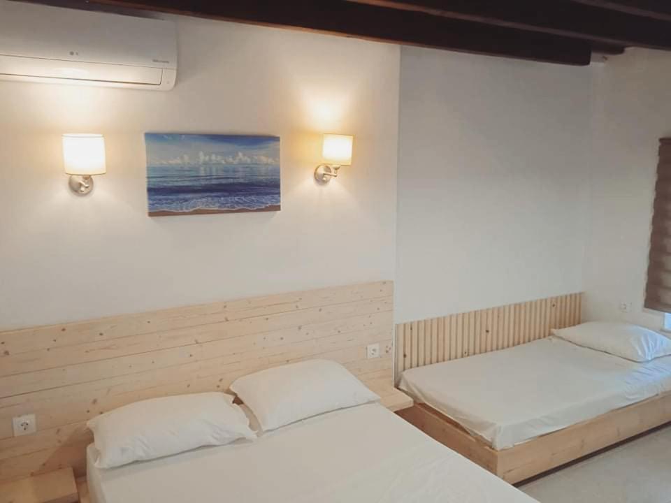Occasus Room Comfort في هالكي: غرفة نوم بسريرين ولوحة على الحائط