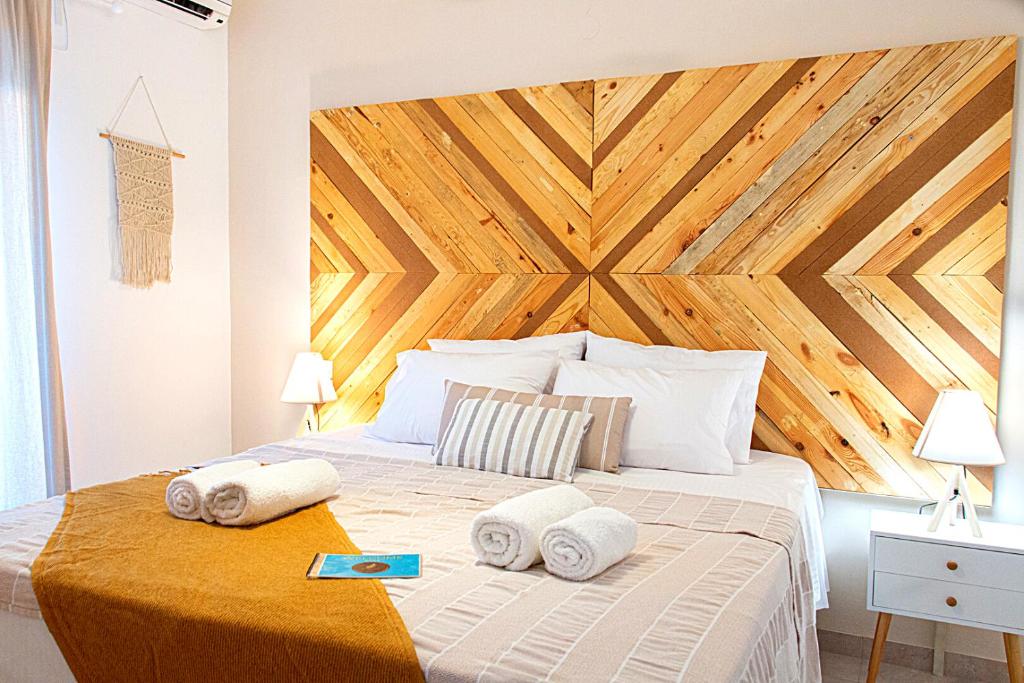 a bedroom with a large bed with towels on it at Summer Feel suites in Poros