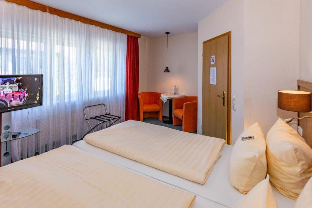 a hotel room with two beds and a television at Hotel Spitzenhoernbucht in Wolgast