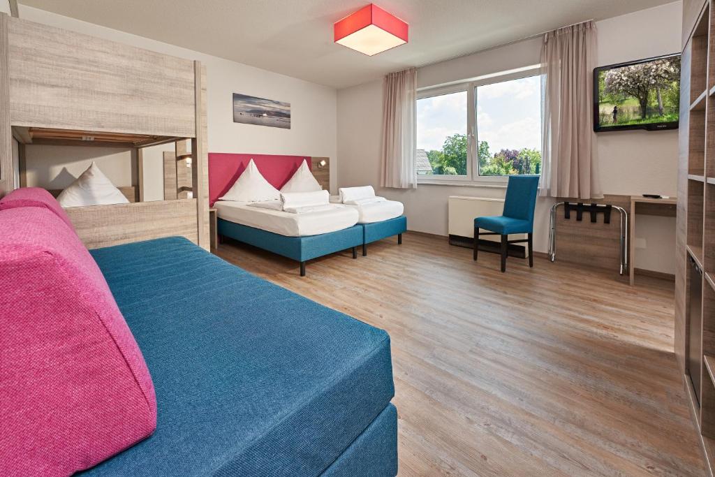 une chambre d'hôtel avec un lit et un canapé dans l'établissement Gästehaus Mythos, à Rust