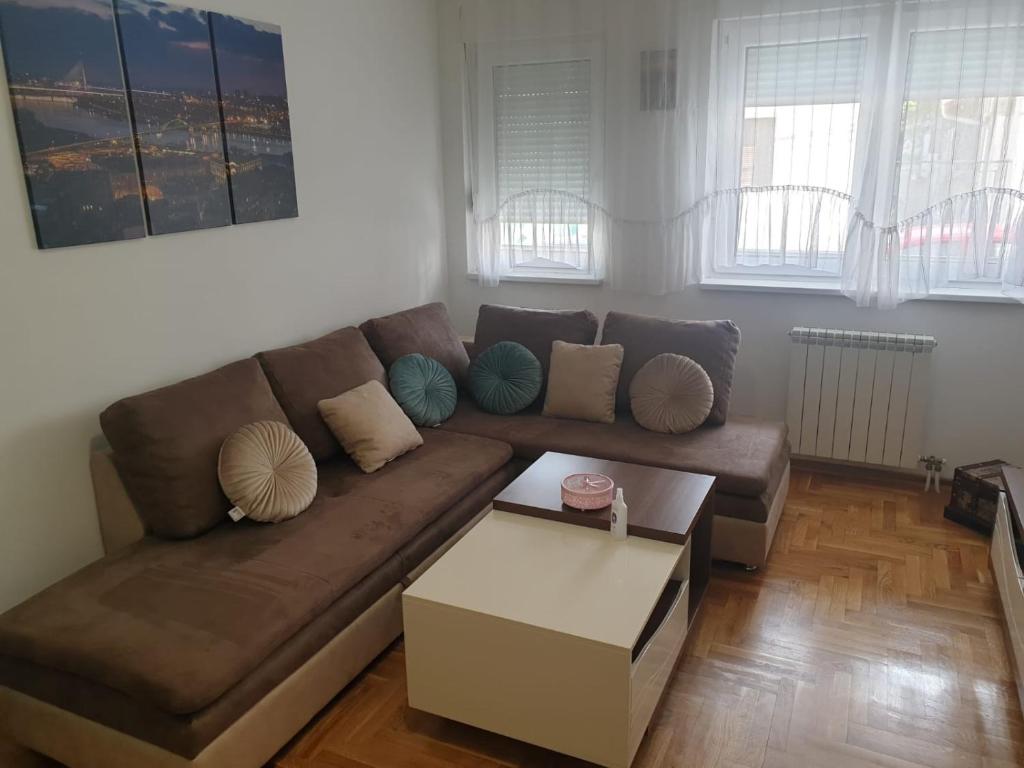 uma sala de estar com um sofá castanho e uma mesa de centro em Belgradian 011 em Belgrado