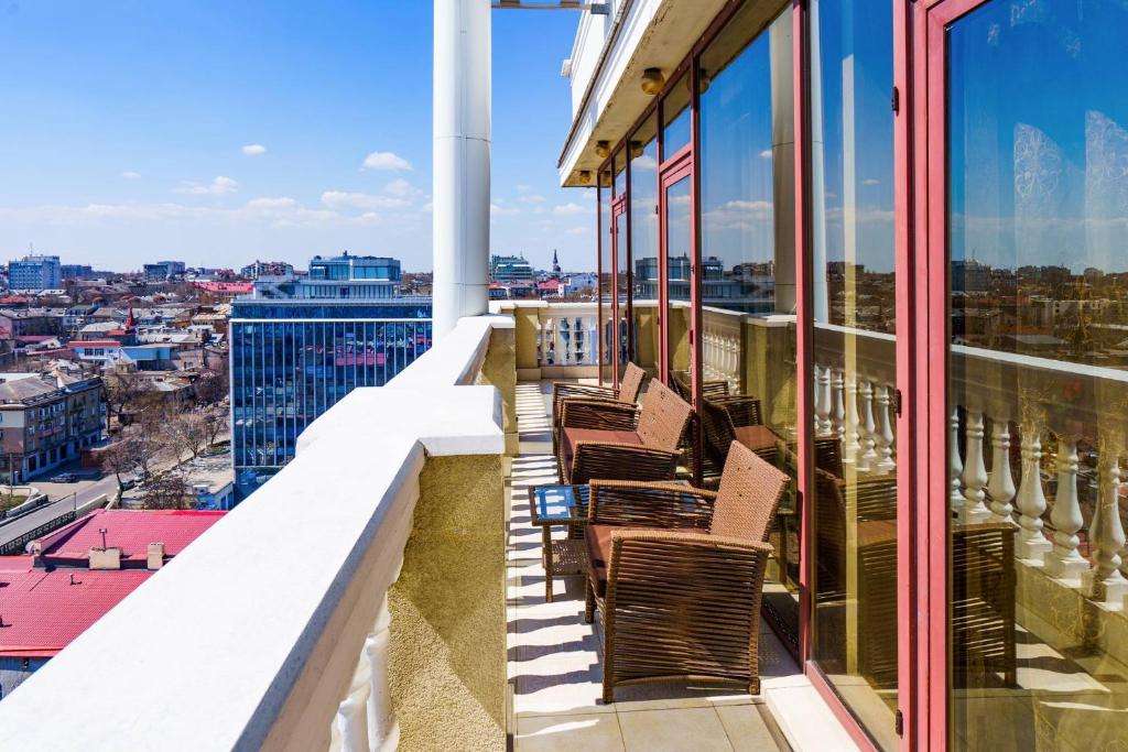 una fila de sillas sentadas en el balcón de un edificio en Gefest Apartments, en Odessa