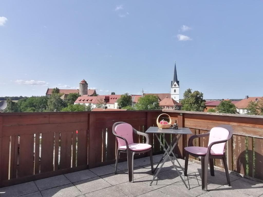 a patio with a table and chairs on a balcony at Ferienwohnung Burgblick in Lisberg