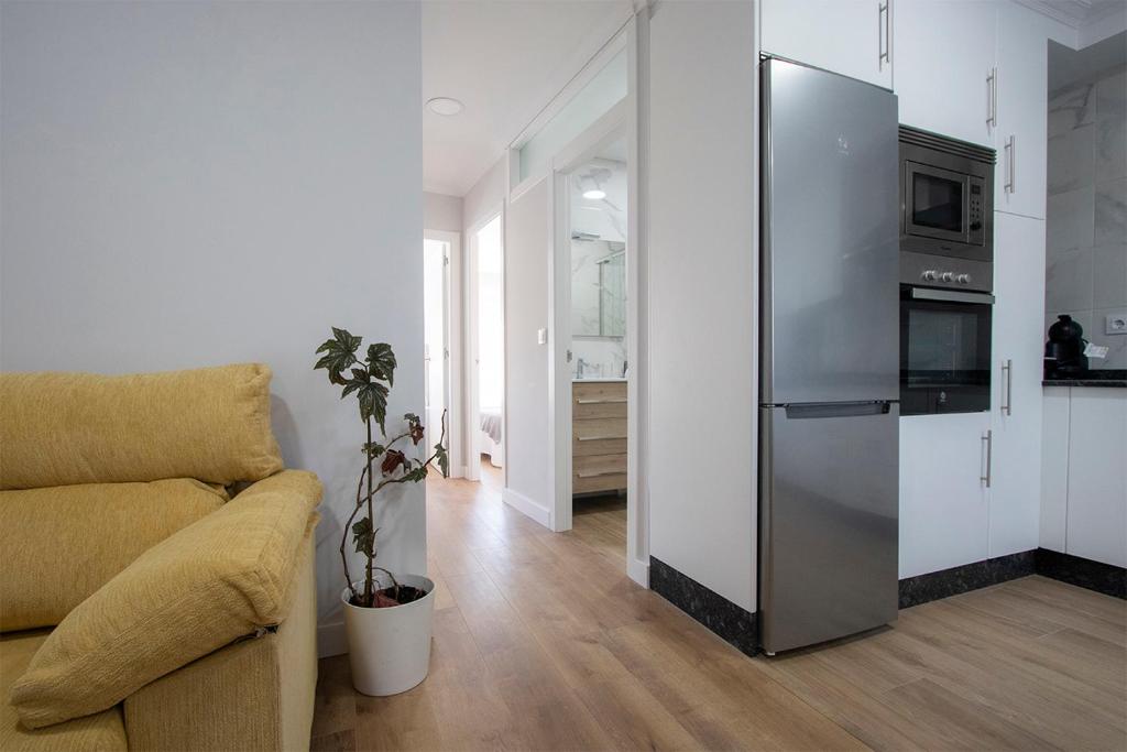 salon z kanapą i lodówką w obiekcie Precioso apartamento en Marín. w mieście Marín