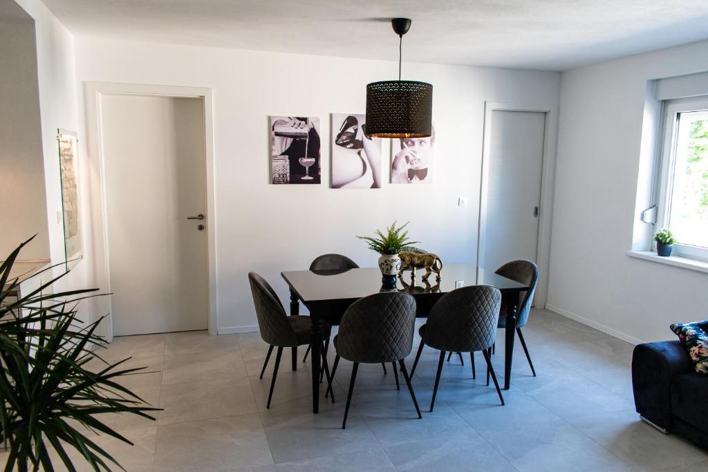 une salle à manger avec une table et des chaises noires dans l'établissement Apartmaji na placu, à Renče