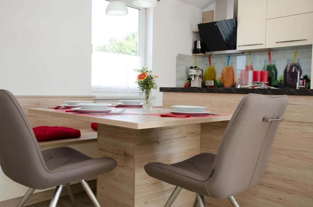 a kitchen with a wooden table and two chairs at Voitsberg-Apartments in Voitsberg