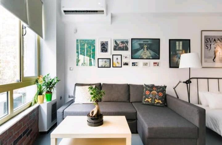 sala de estar con sofá y mesa en Explore a New Arts District from a Hip Studio Flat en Atenas