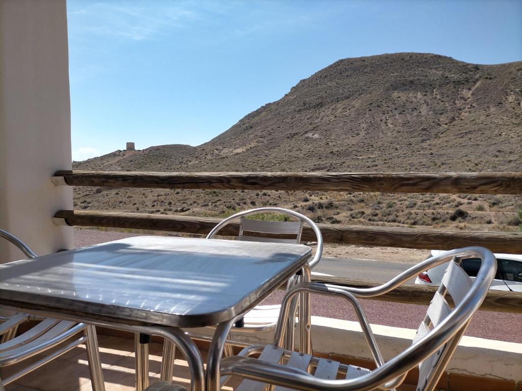 a table and chairs on a balcony with a mountain at Casa Paulonia in Las Negras