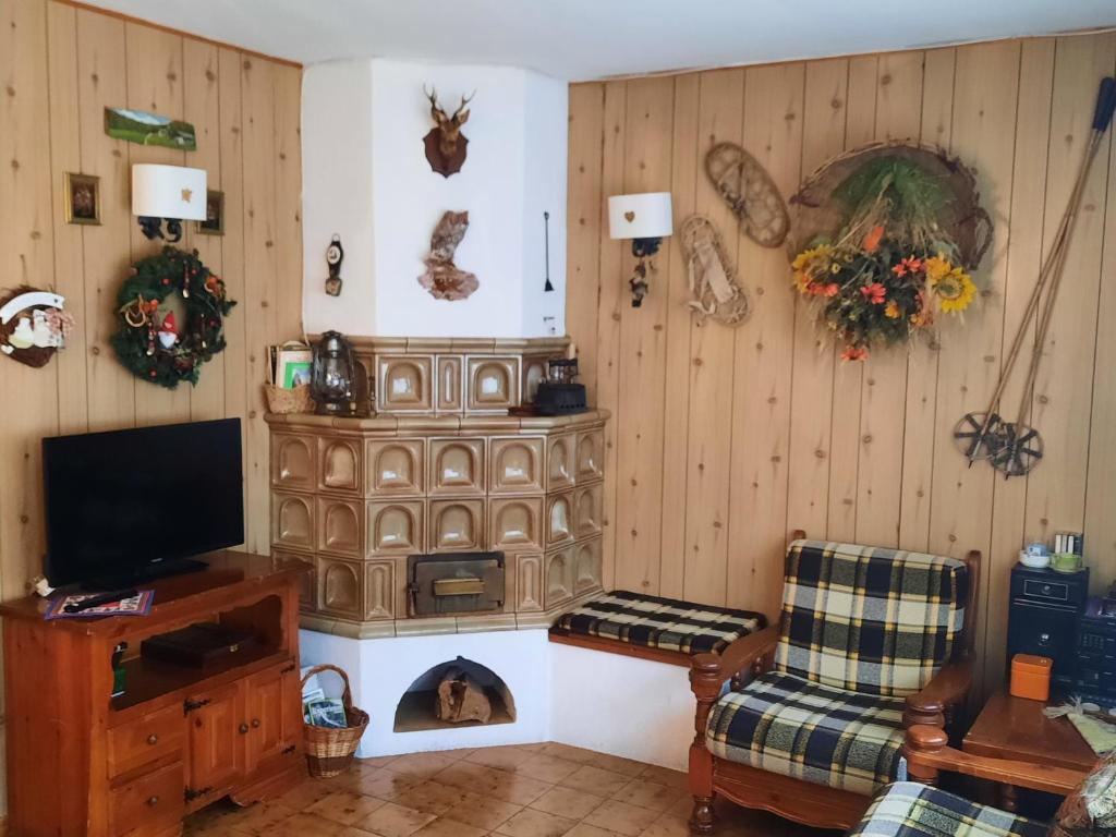 sala de estar con TV y chimenea en Casa Fiore en Dimaro