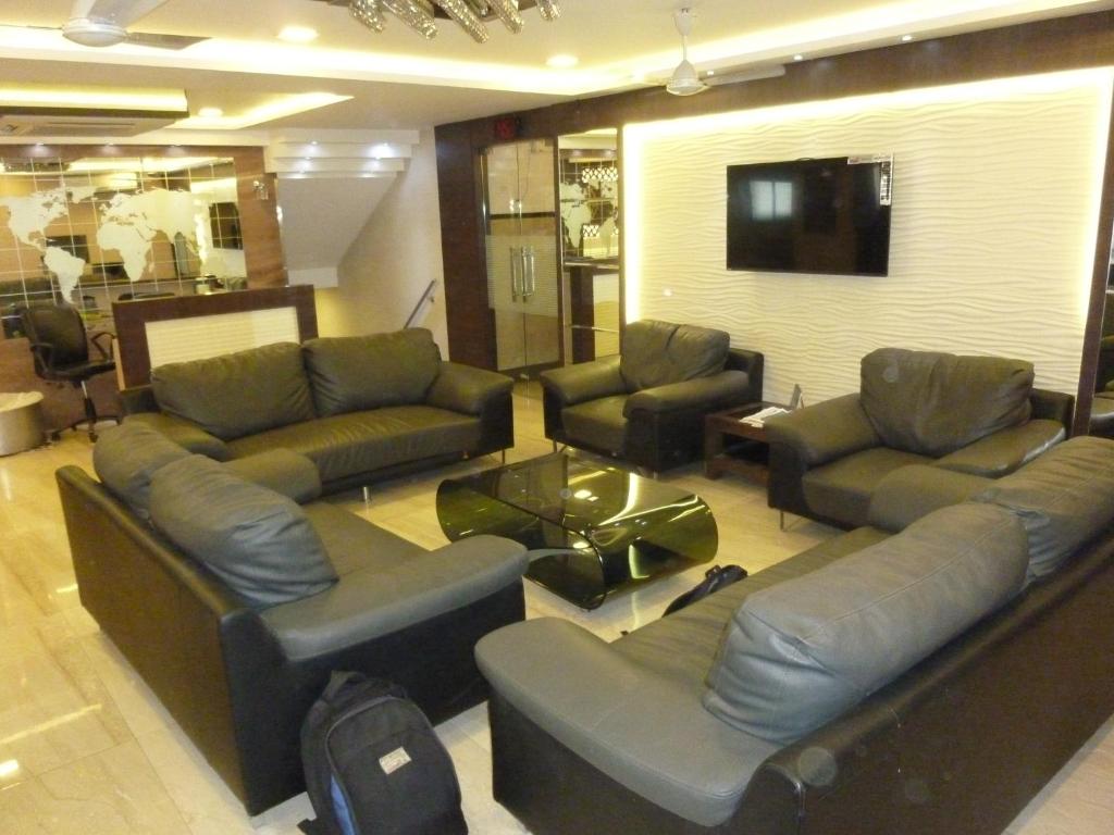 un soggiorno con divani e TV a schermo piatto di Hotel Orient Palace a Mumbai