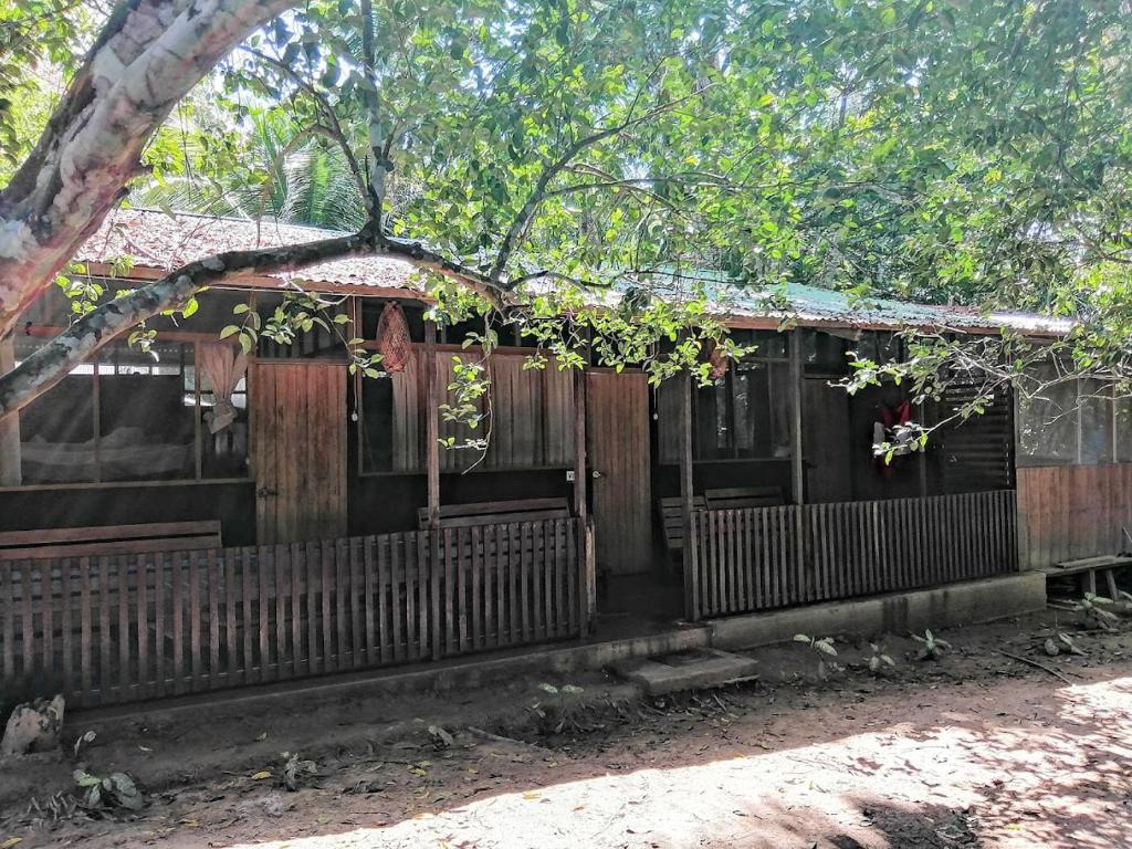 stary drewniany dom z płotem w obiekcie Don Jaime - Hostel w mieście Puerto Maldonado