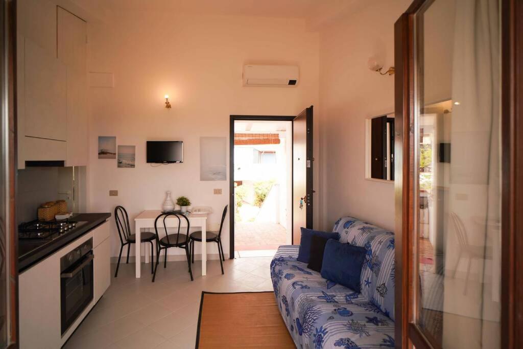 a living room with a couch and a kitchen with a table at Sea View Vista Mare - Soggiorni settimanali da sabato a sabato in Isola Capo Rizzuto