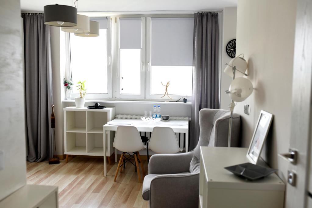 uma pequena sala de estar com uma mesa e uma cadeira em Na chmury i góry - apartament em Klodzko