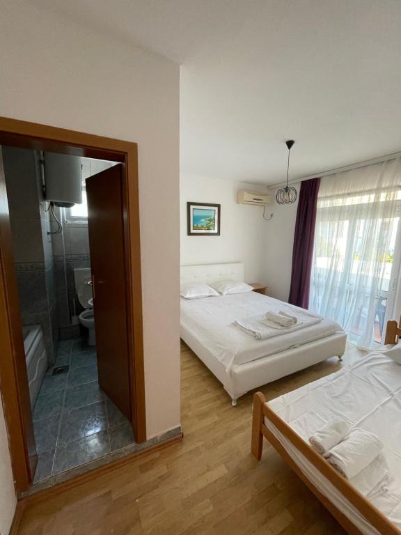 una camera d'albergo con due letti e uno specchio di Apartments Dibra a Ulcinj
