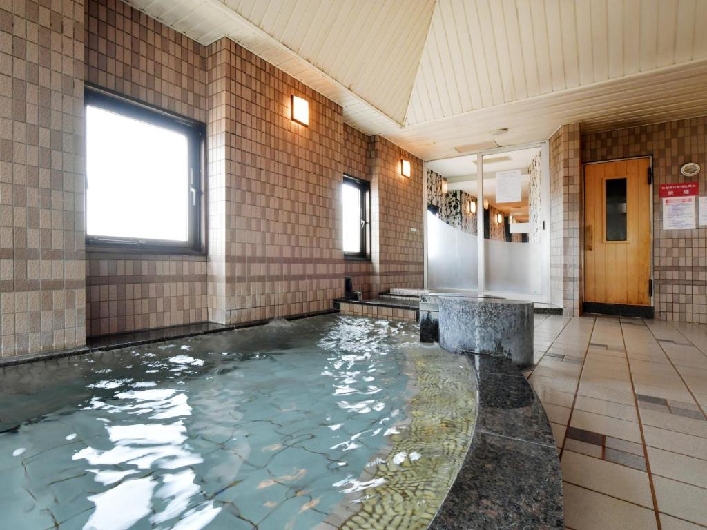 a bathroom with a pool of water in a building at APA Hotel Ogaki Ekimae in Ogaki