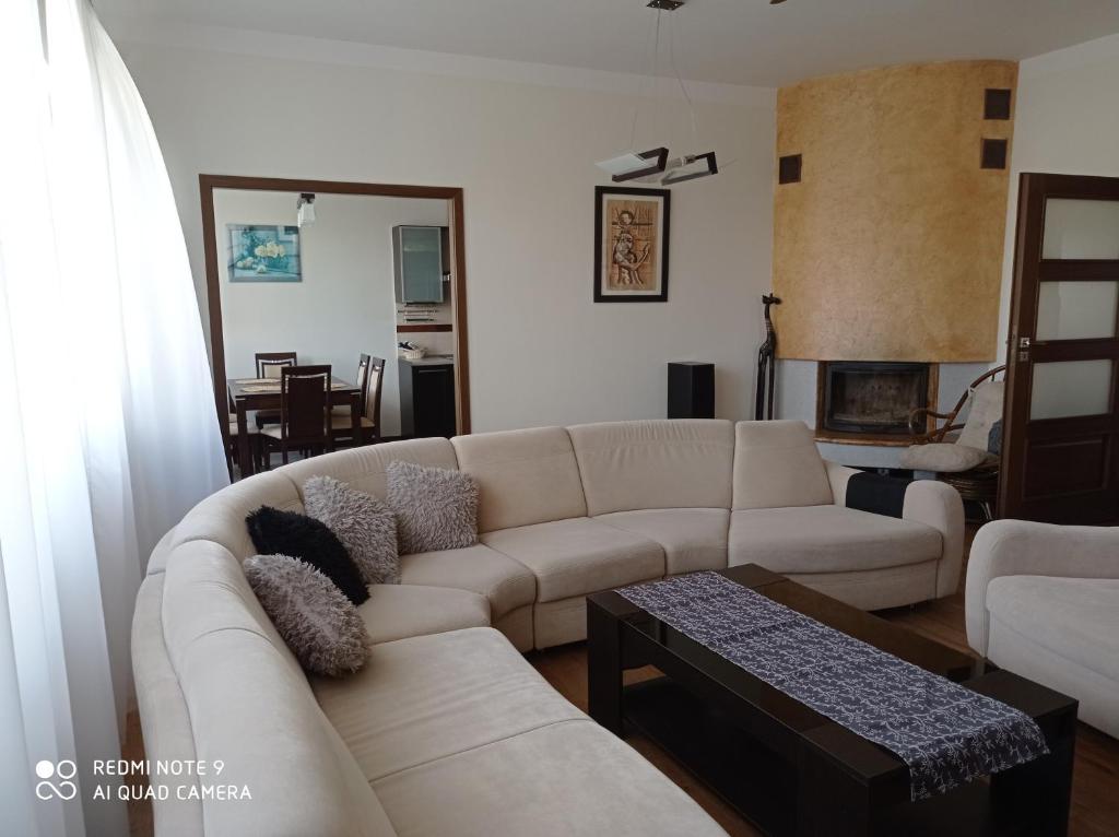 uma sala de estar com um sofá branco e uma mesa em Apartament Wanessa em Ketrzyn