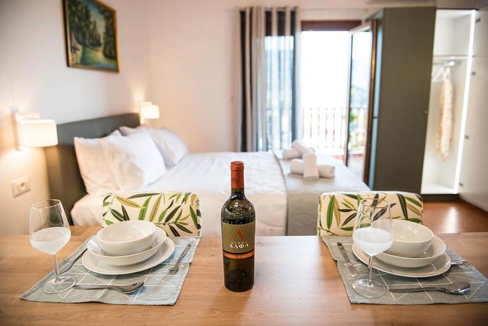 una botella de vino sentada en una mesa con platos y vasos en Sophie's Apartment 1&2, en Poros