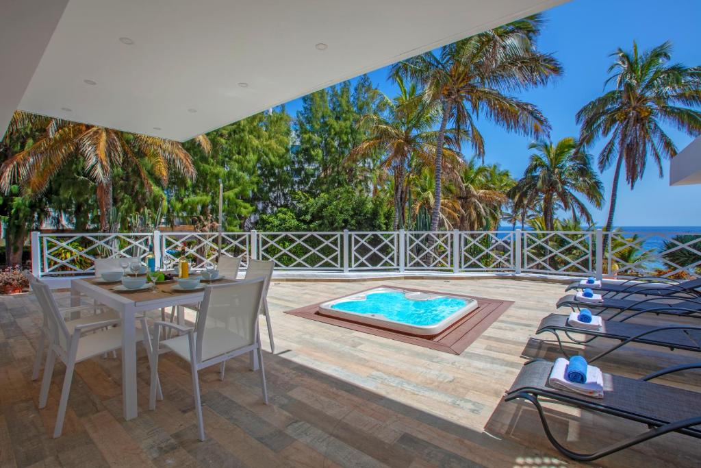 een patio met een tafel en stoelen en een zwembad bij PLAYA CHICA by Buenavilla in Puerto del Carmen