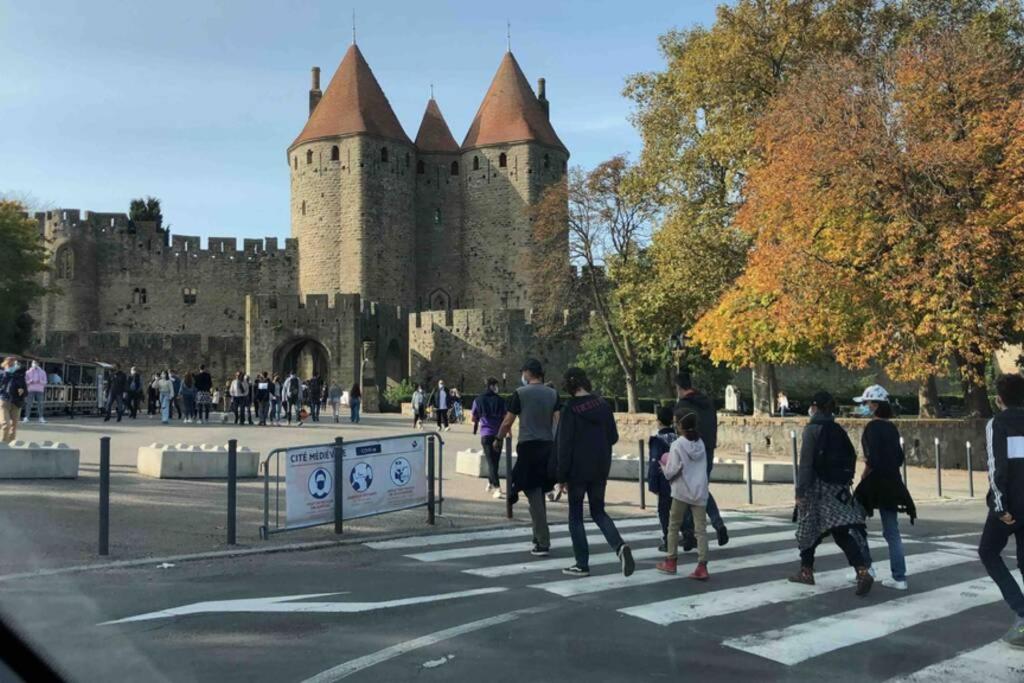 un groupe de personnes marchant devant un château dans l'établissement Romantic house - entrance to the medieval castle, à Carcassonne