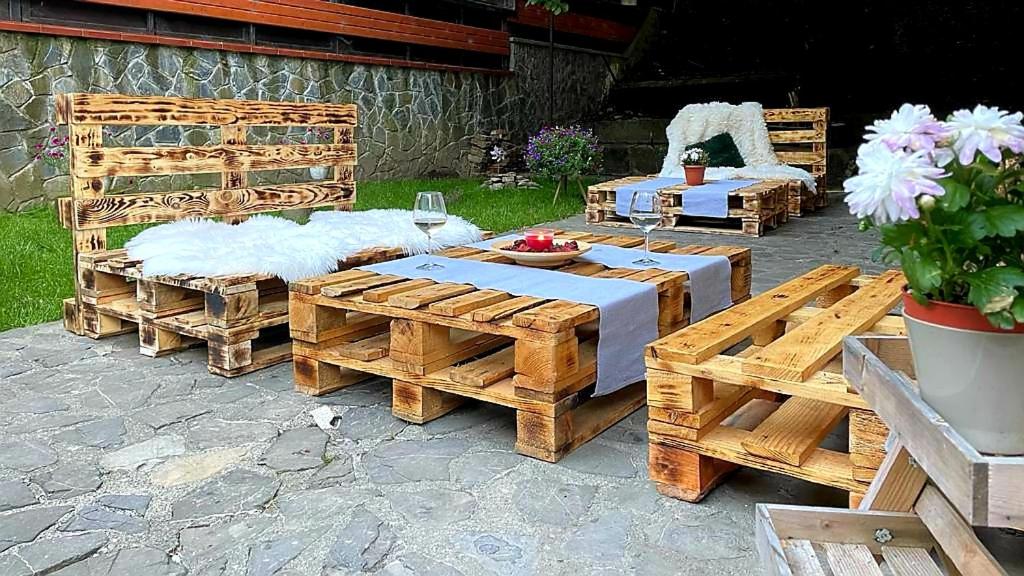 a patio with two beds and a table and chairs at Pensiunea Don Sergio in Predeal