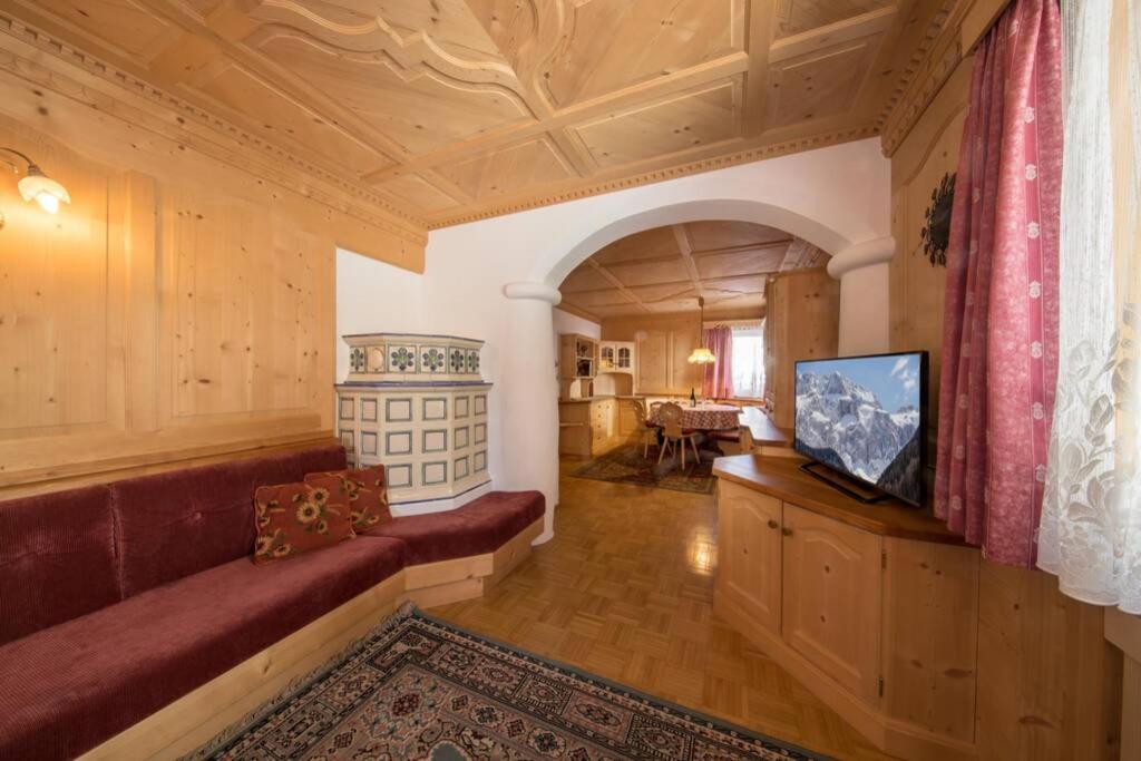 a living room with a couch and a tv at Chalet Merisana in Selva di Val Gardena