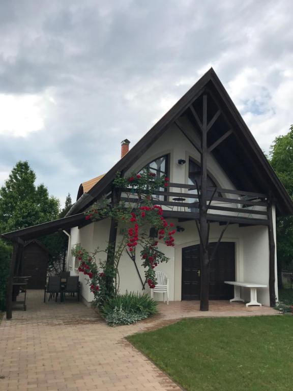 Una casa con una pérgola con flores. en Rózsa Porta, en Vonyarcvashegy