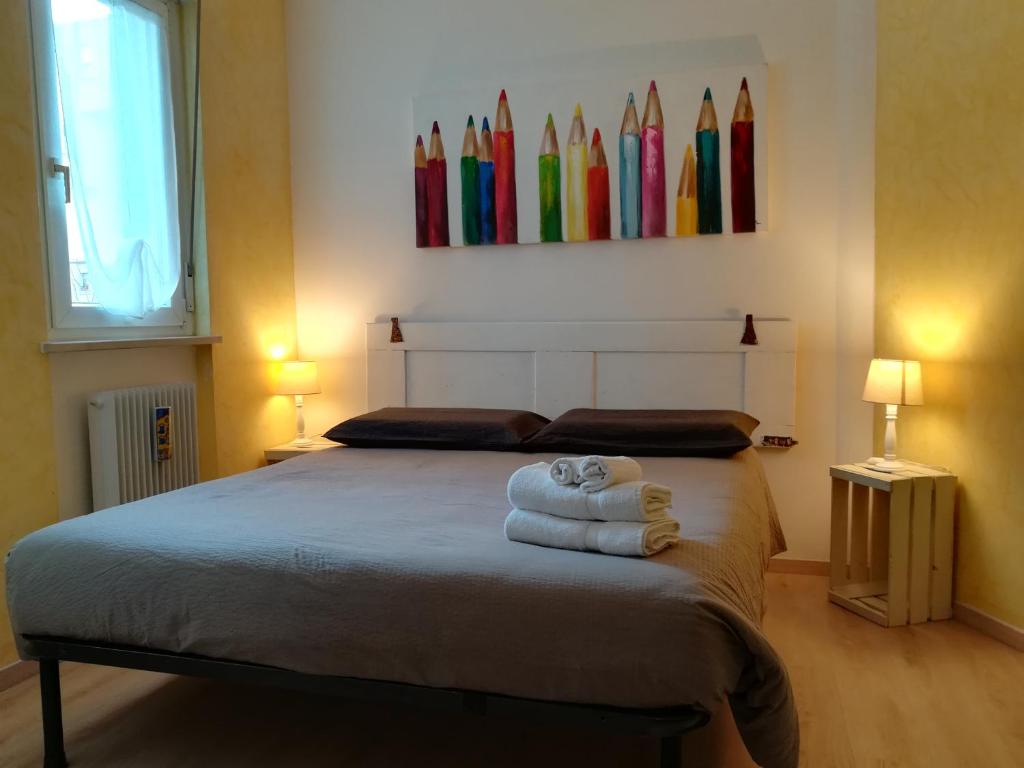una camera da letto con un letto e asciugamani di B & B Color Rovereto a Rovereto