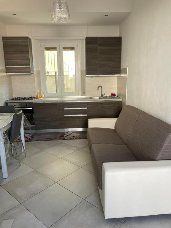 a living room with a couch and a kitchen at Blu Mare House in Cecina