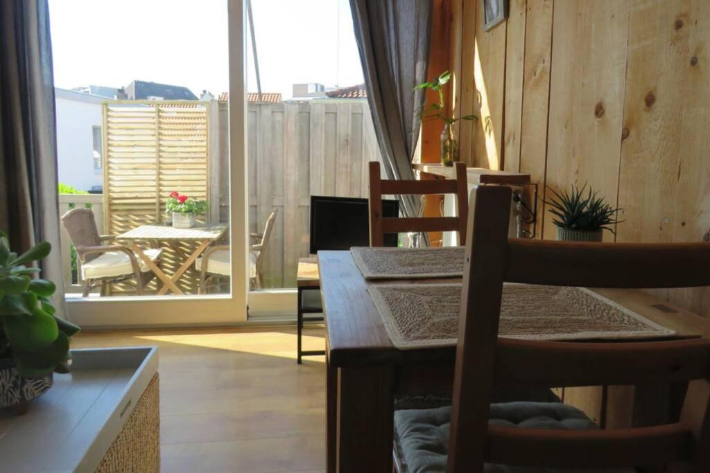 ein Esszimmer mit einem Tisch und Stühlen sowie einem Balkon in der Unterkunft Beachtime close to the beach, city centre in Zandvoort