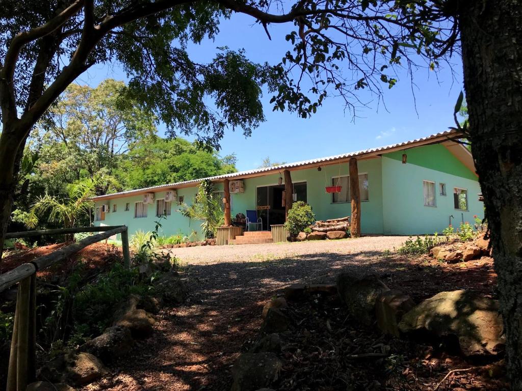 a house with a tree in front of it at Pousada Vale de Luz in Frederico Westphalen