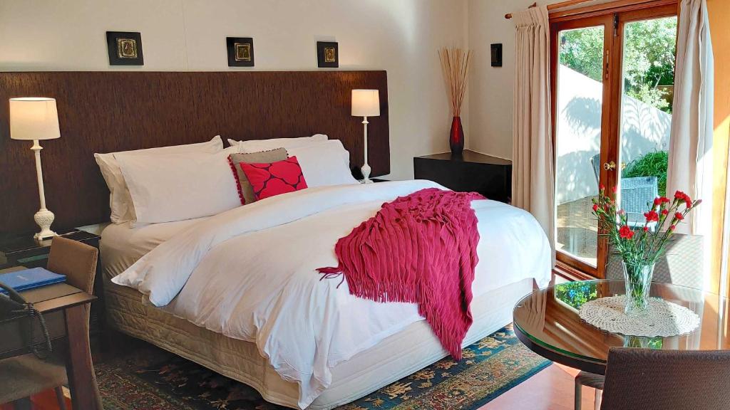 a bedroom with a bed with a red blanket on it at Moon Gate Villa in Kerikeri